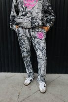 model wearing hot mess at heart camo set showing the camo sweatpants with pink text and pink graphic 