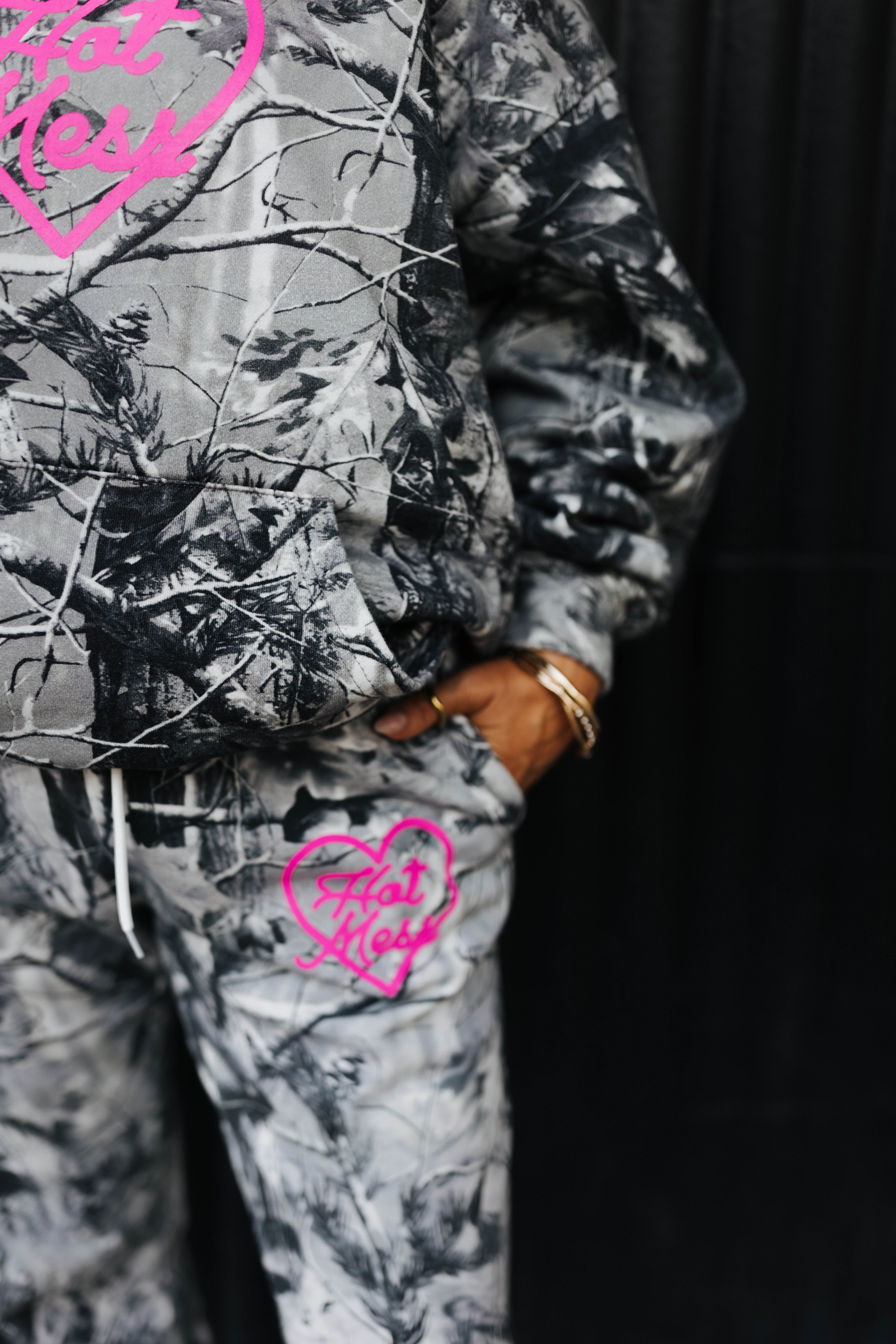 model close up wearing hot mess at heart camo set with hand in pocket against black wall 