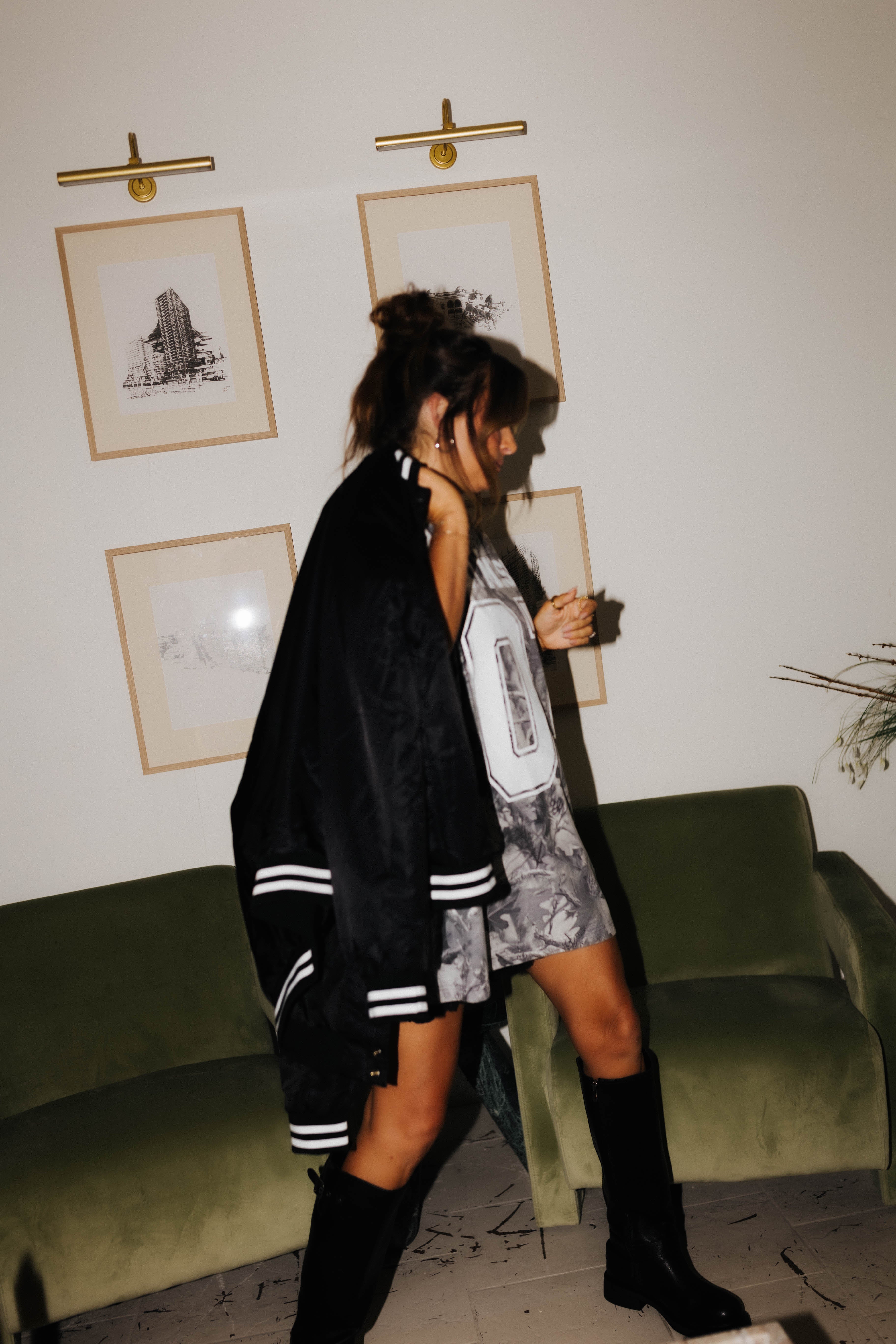 model looking away from camera while holding hot mess bomber jacket over shoulder 