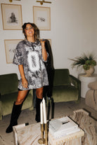 model laughing at camera wearing camo tee with hot mess 01 text and jacket over shoulder 