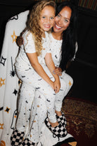 Child sitting with an adult in matching Halloween Icon Print pajamas