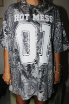 front of camo tee with hot mess 01 in bold letters 