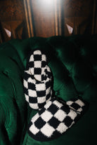 Sand and black check slippers arranged on a green chair