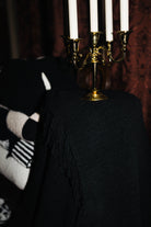 Black Waffle Fringe Blanket 90x90 shown in a full length lifestyle view