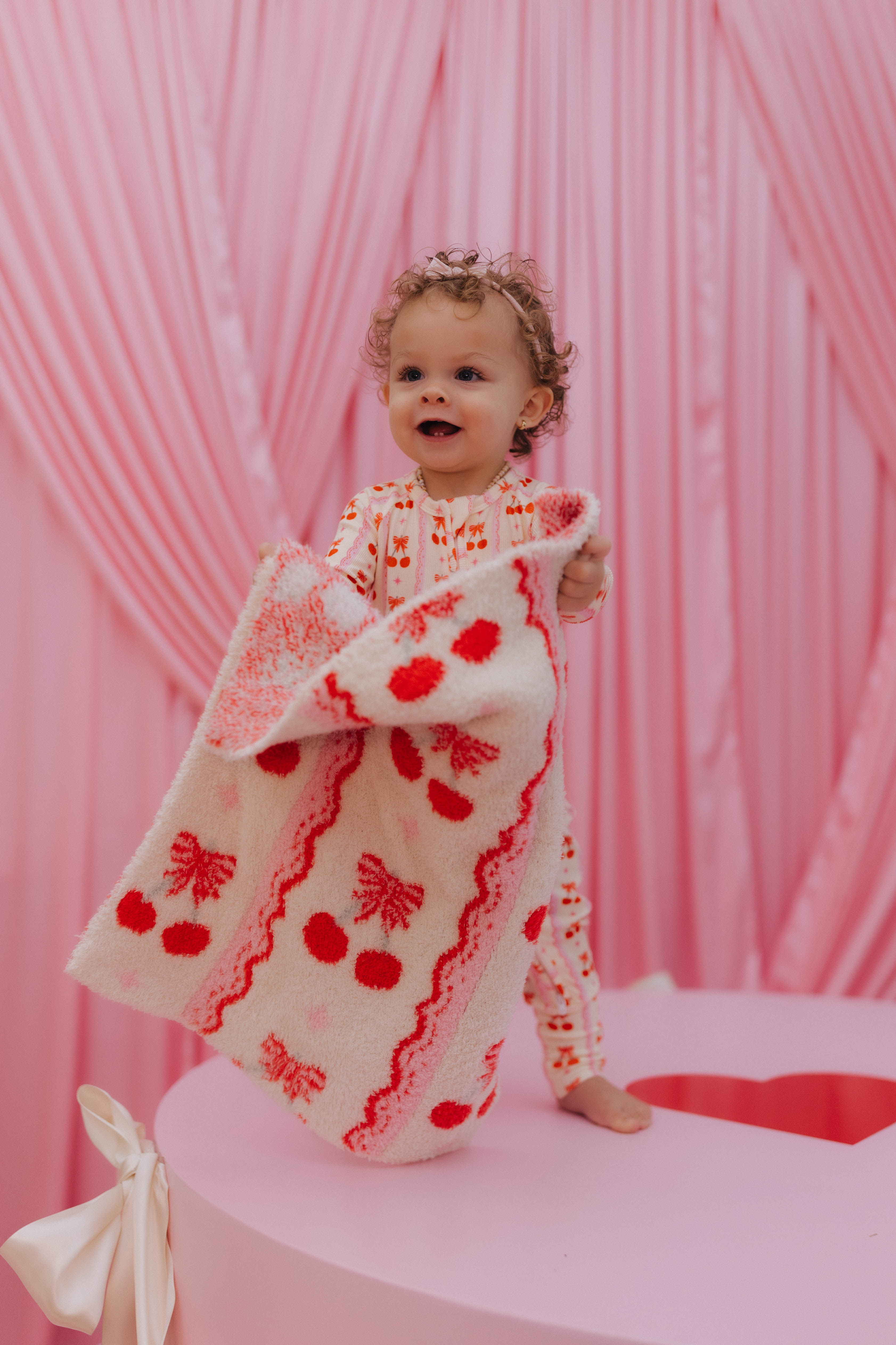 baby holding up the lovey blanket