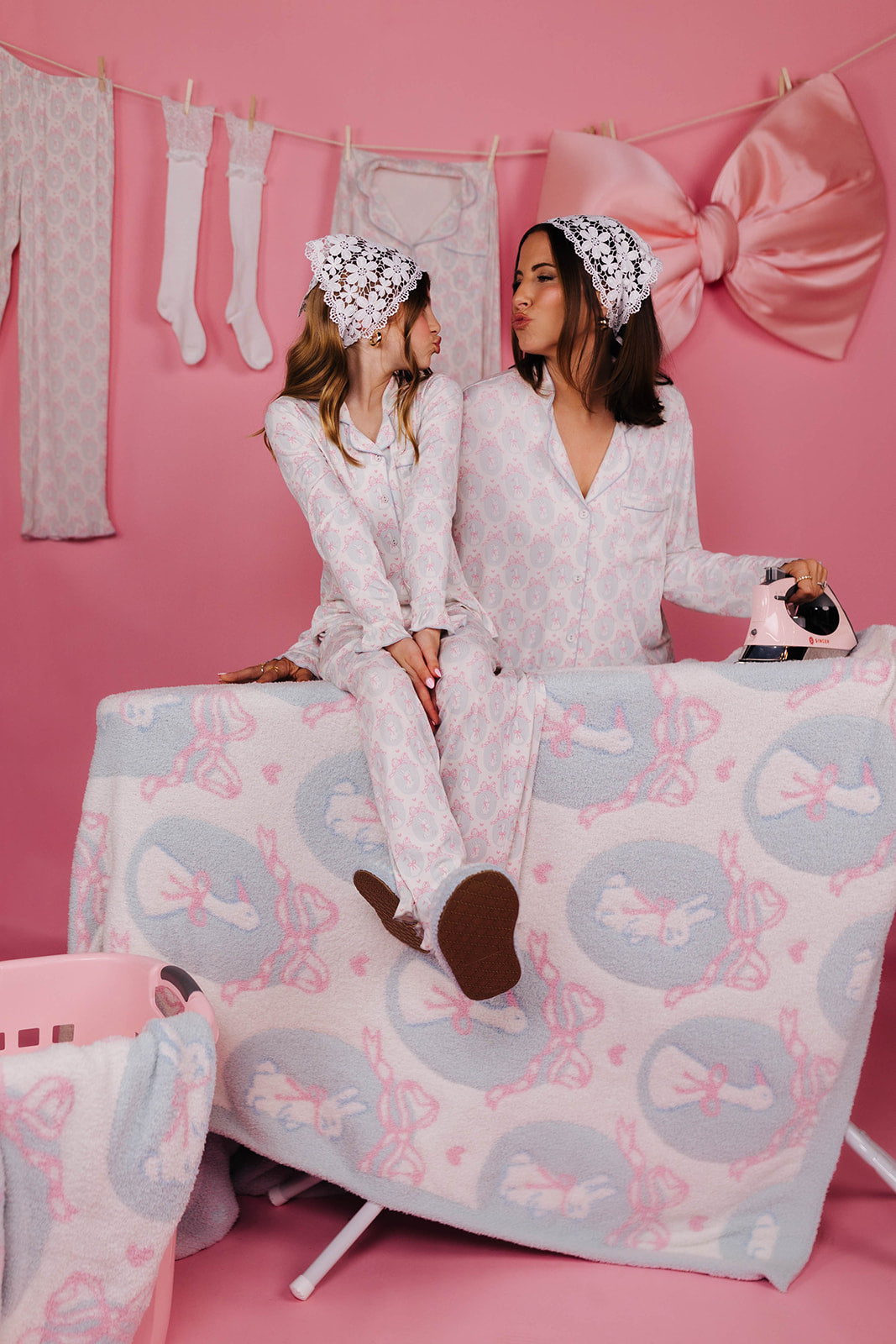 Kolly sitting on the ironing board looking at Krista while making kissy faces 