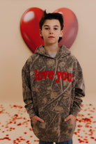 Boss in a camo kids XL sweatshirt that says love you