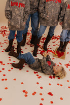 Kamp shooting a pretend bow and arrow while laying on the ground