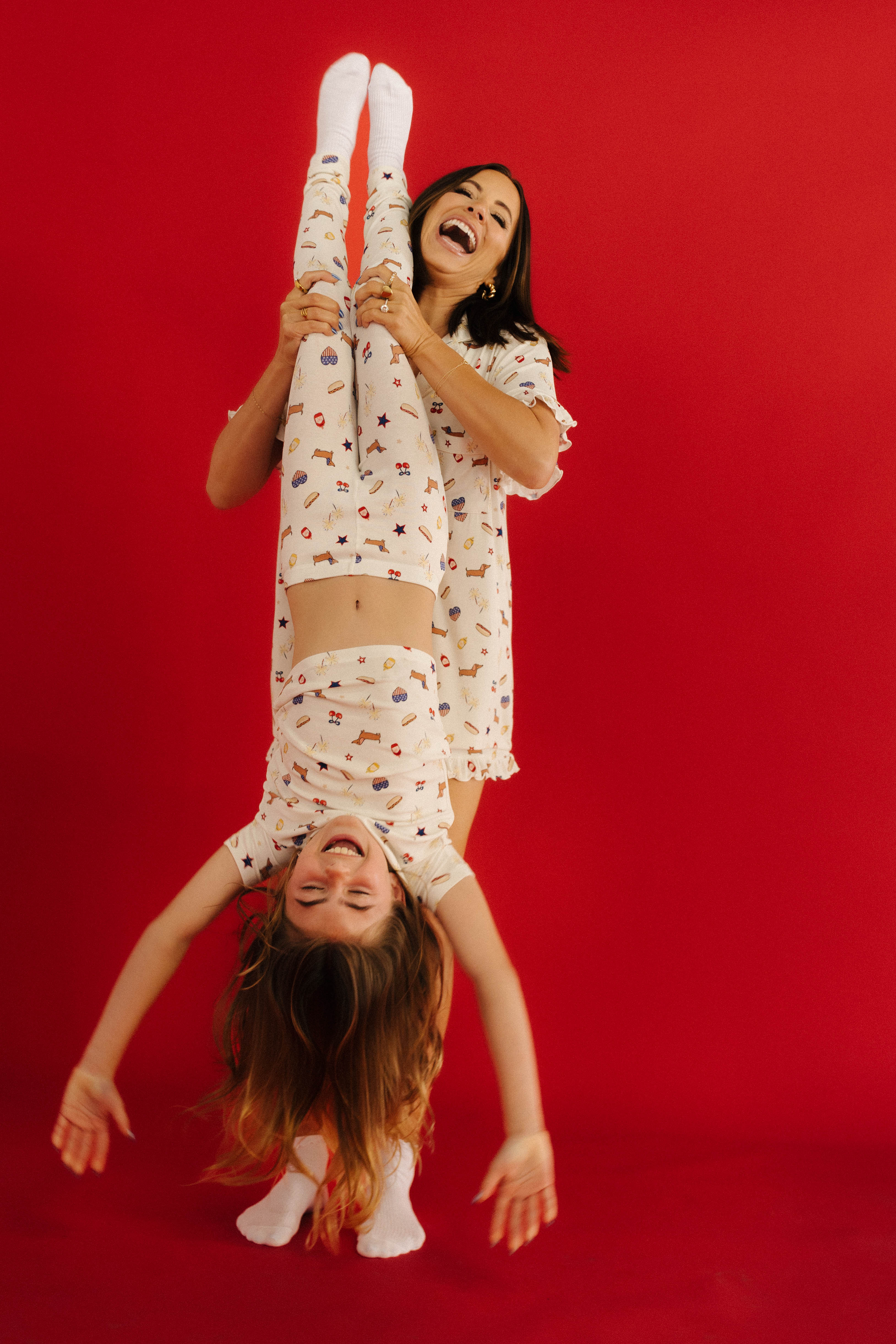 woman holding daughter upside down laughing