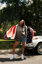 Krista holding the blanket out with her arms and smiling upwards