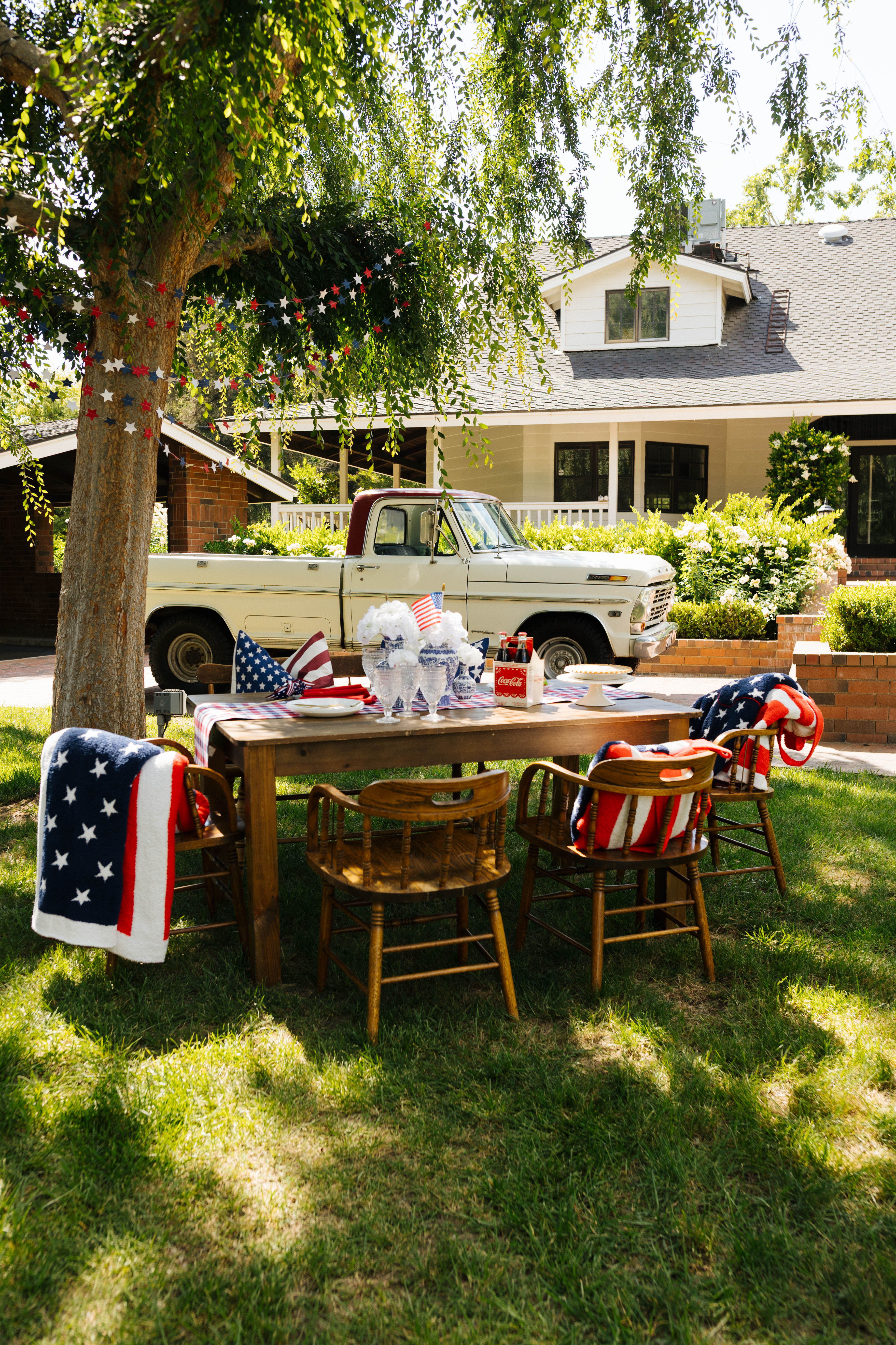 Styled blankets and table in front of a farm house