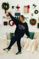 Person in a festive living room with Christmas decorations and presents.