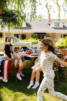 girl running in front of the table quickly with people posing sitting down at it