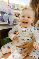 mom holding baby on her lap and baby smiling
