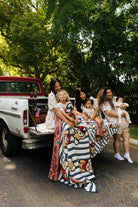 moms and kids sitting on the back of the truck with the teddy blanket over them