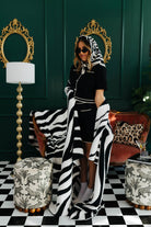 Woman in a stylish room with zebra-patterned blanket and decor