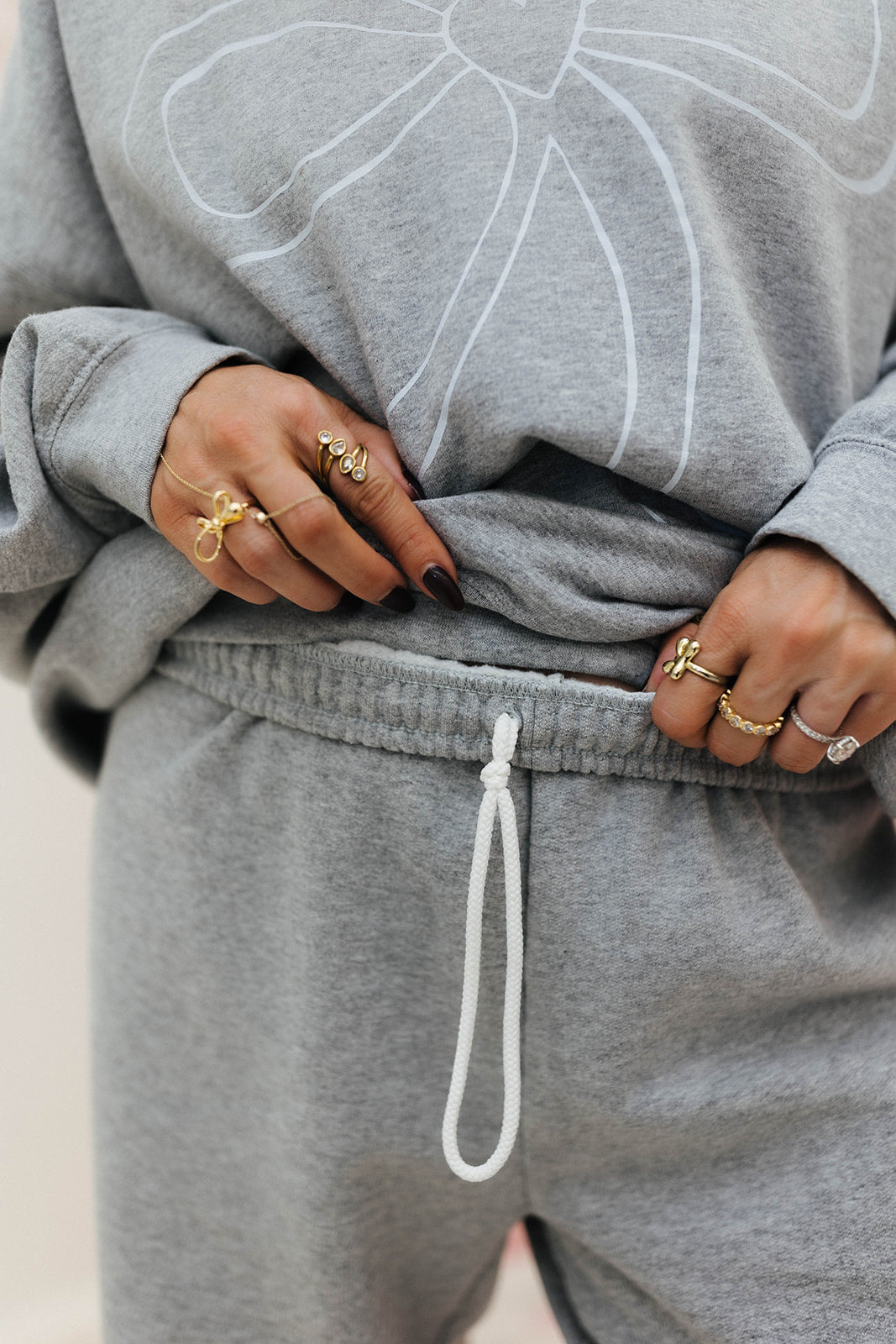 Person wearing a grey set showing the drawstring on the pants