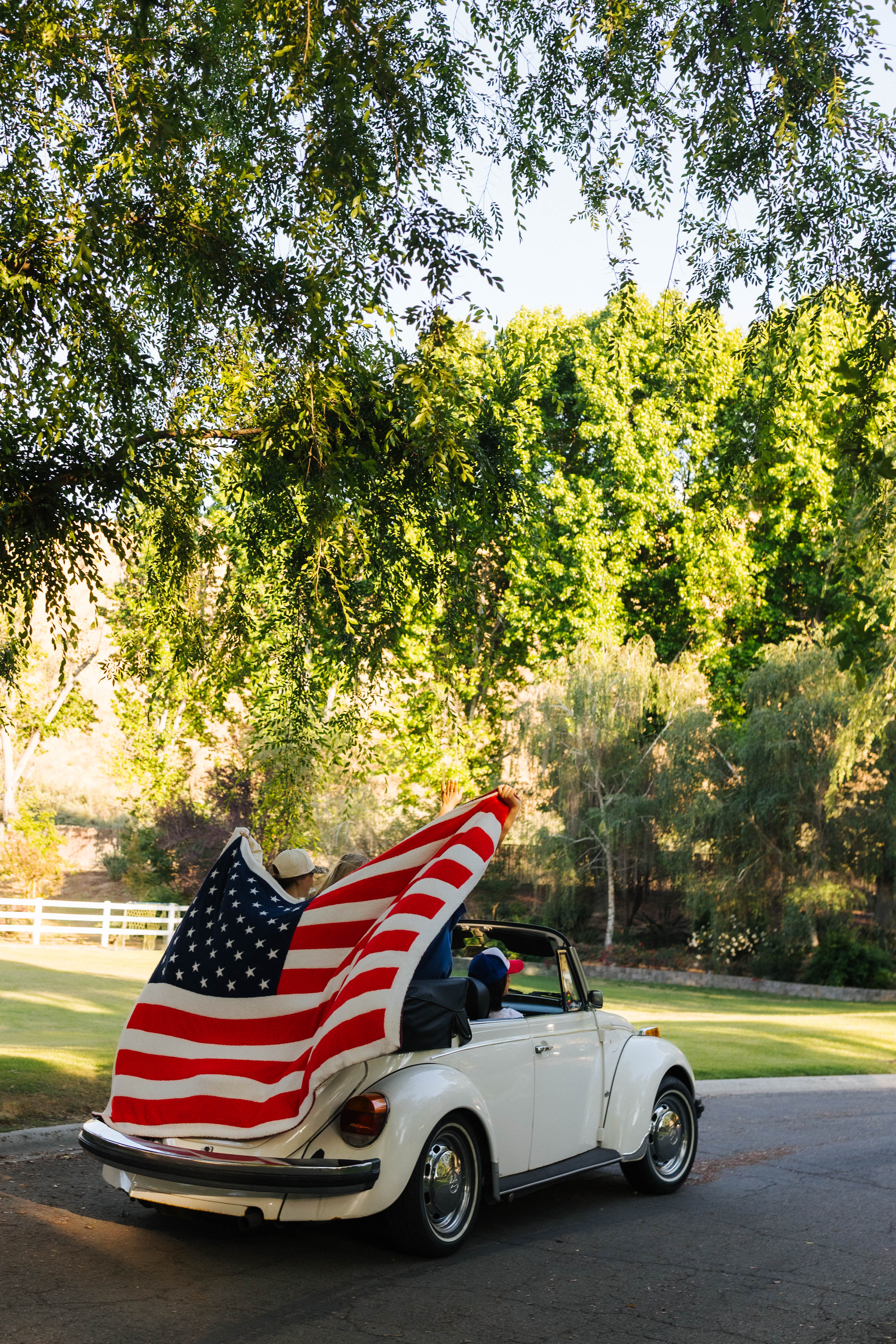american flag blanket being held up while the car is driving