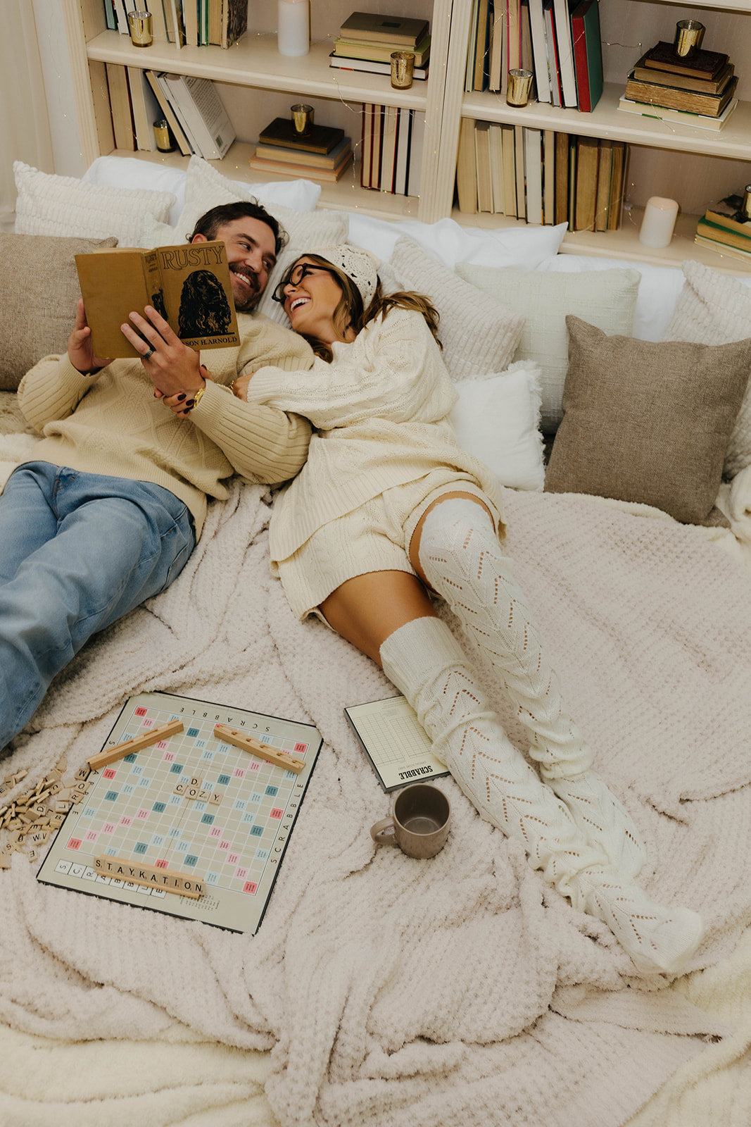 Couple lying on cozy blankets with books 