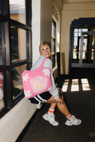 A woman sitting on a windowsill in a hallway, wearing the quillow. 