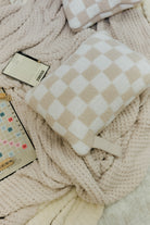 Checkered pillow and notebook on a waffle blanket