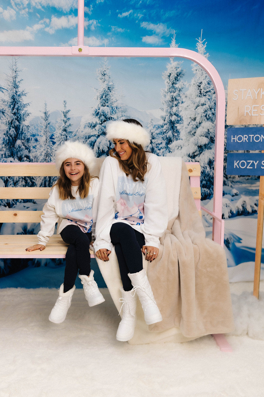 Two people sitting on a pink chair with a snowy background