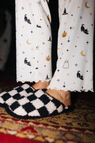 Sand and black check slippers worn with Halloween Icon Print pajamas