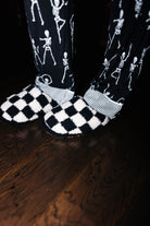Sand and black check slippers worn with Skelly pajamas