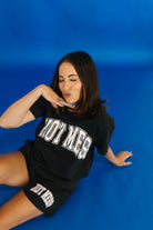 Woman wearing a black t-shirt and shorts with 'HOT MESS' text on a blue background