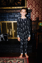 Front view of kids Skelly long pajamas on an older child