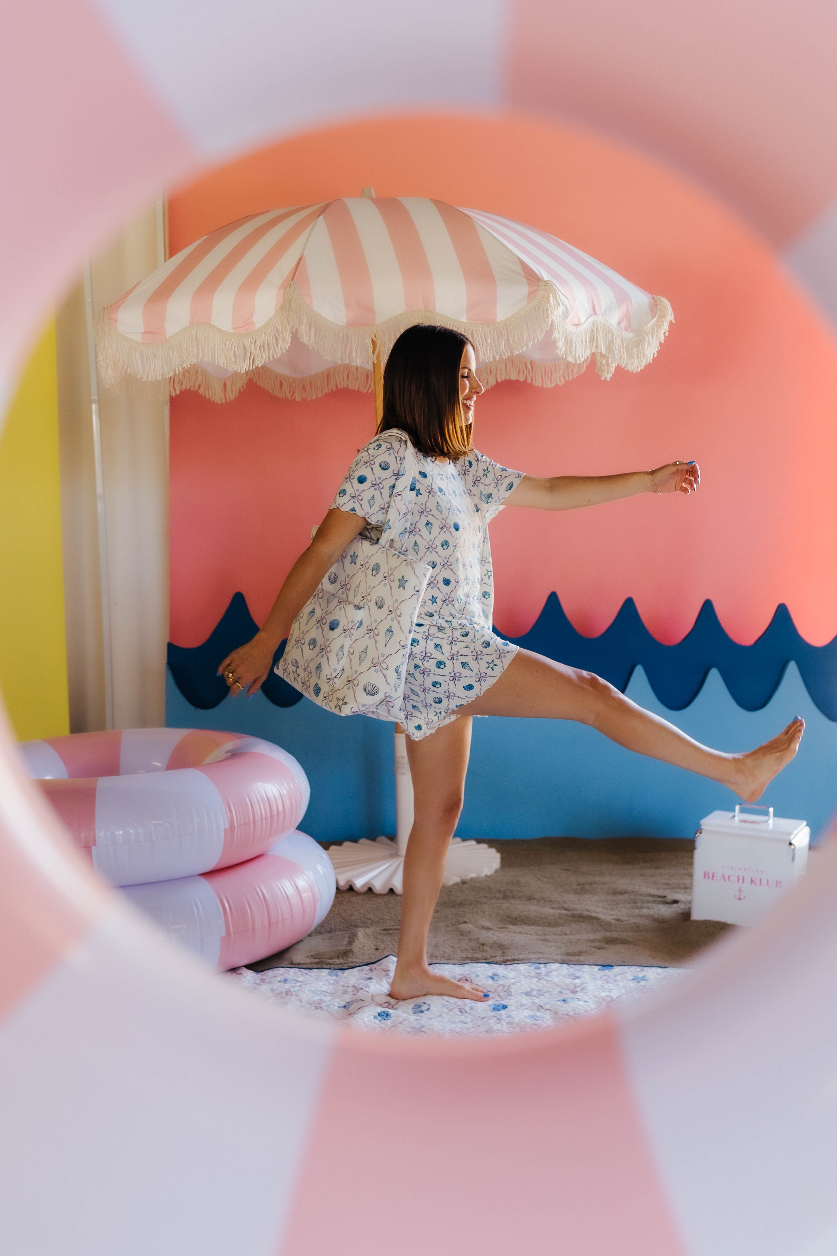 Woman playing with a beach-themed inflatable slide and umbrella
