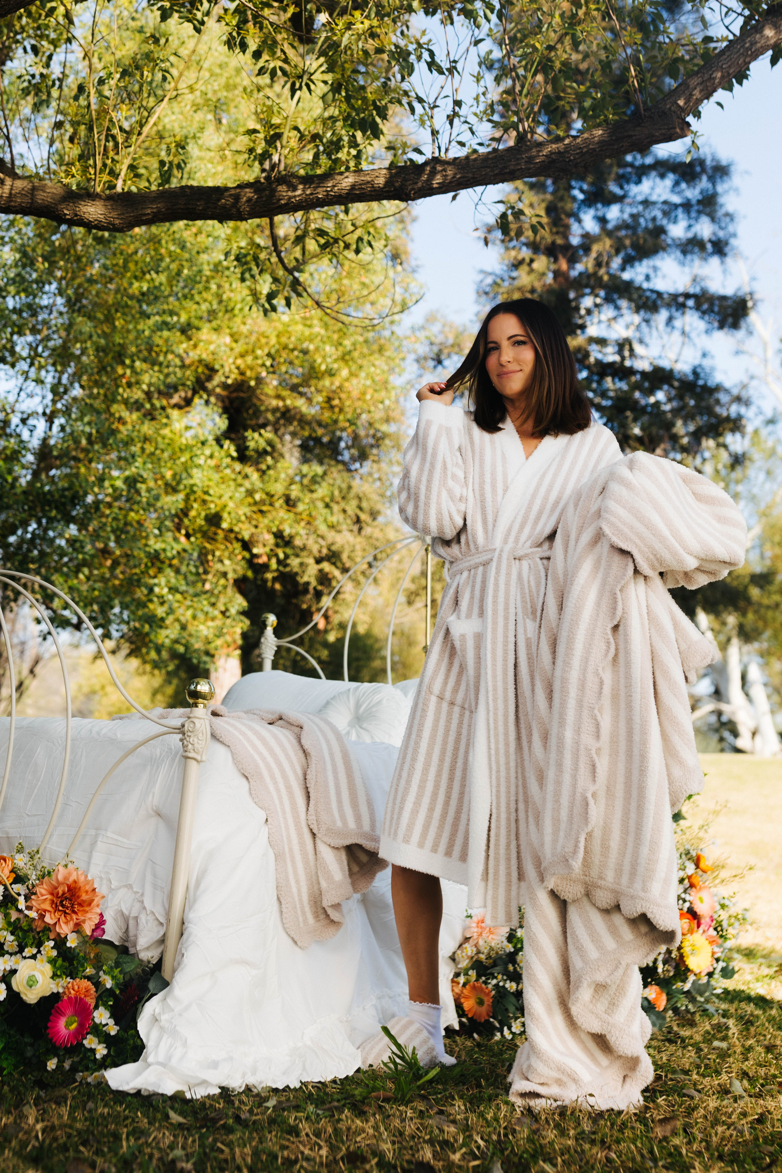 Krista holding the scalloped pinstripe blanket while modeling the pinstripe robe
