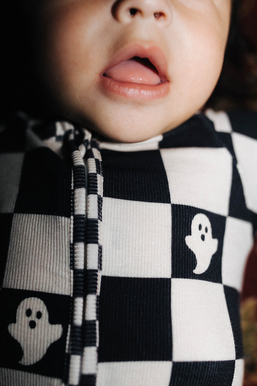 Close-up of a baby wearing a black and check pjs 