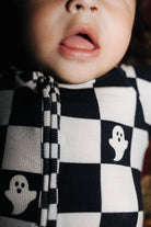 Close-up of a baby wearing a black and check pjs 