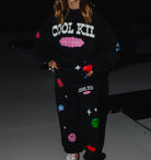 Sweatpants showing the cool kid logo and the not like a regular kid text along with the flowers, dice, smiley, hearts and flowers. 