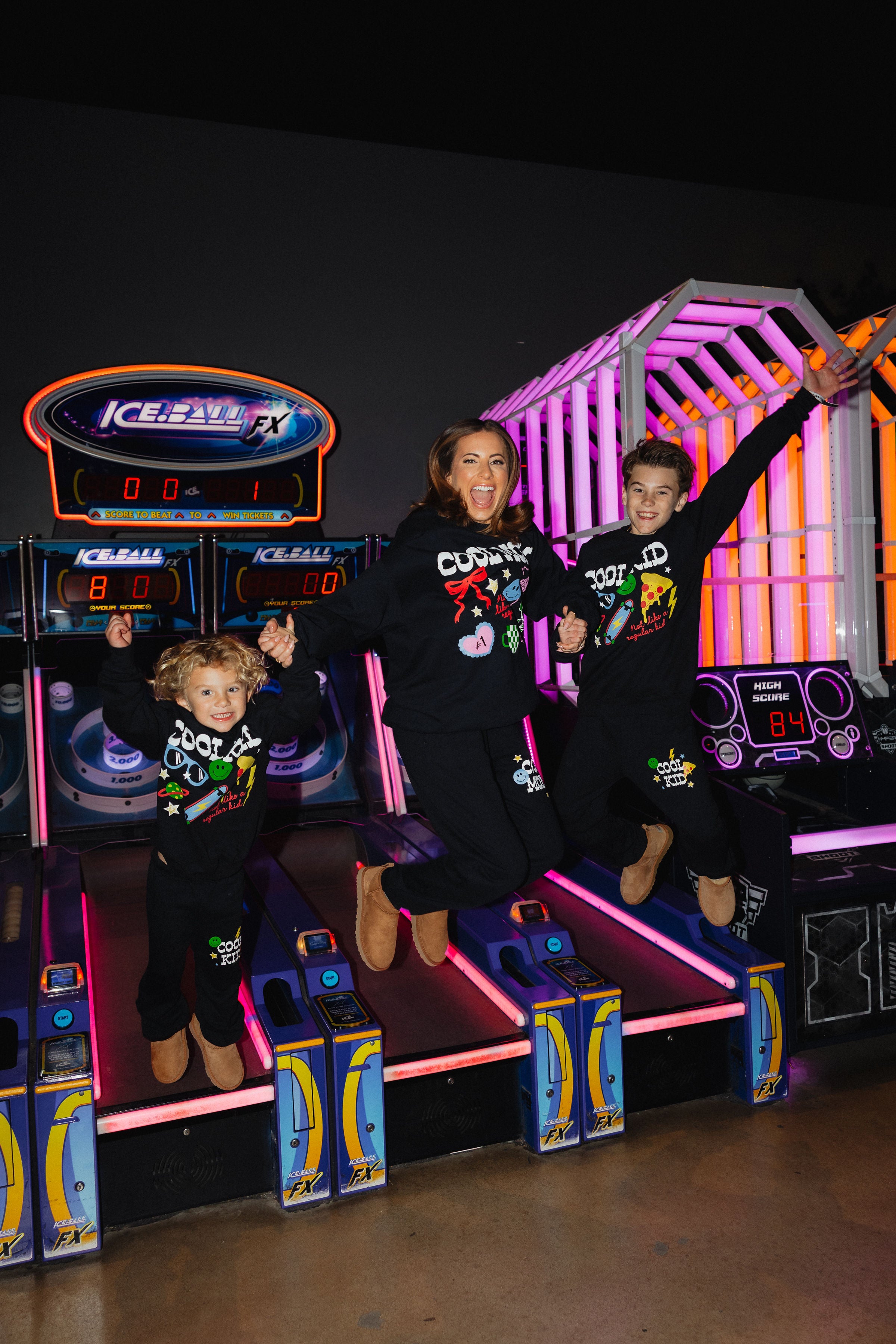 Krista Boss and Kamp jumping in the air off of the arcade game