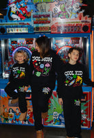 Kamp sitting on an arcade machine with Krista in the middle and boss on the side! Smiling and posing. 