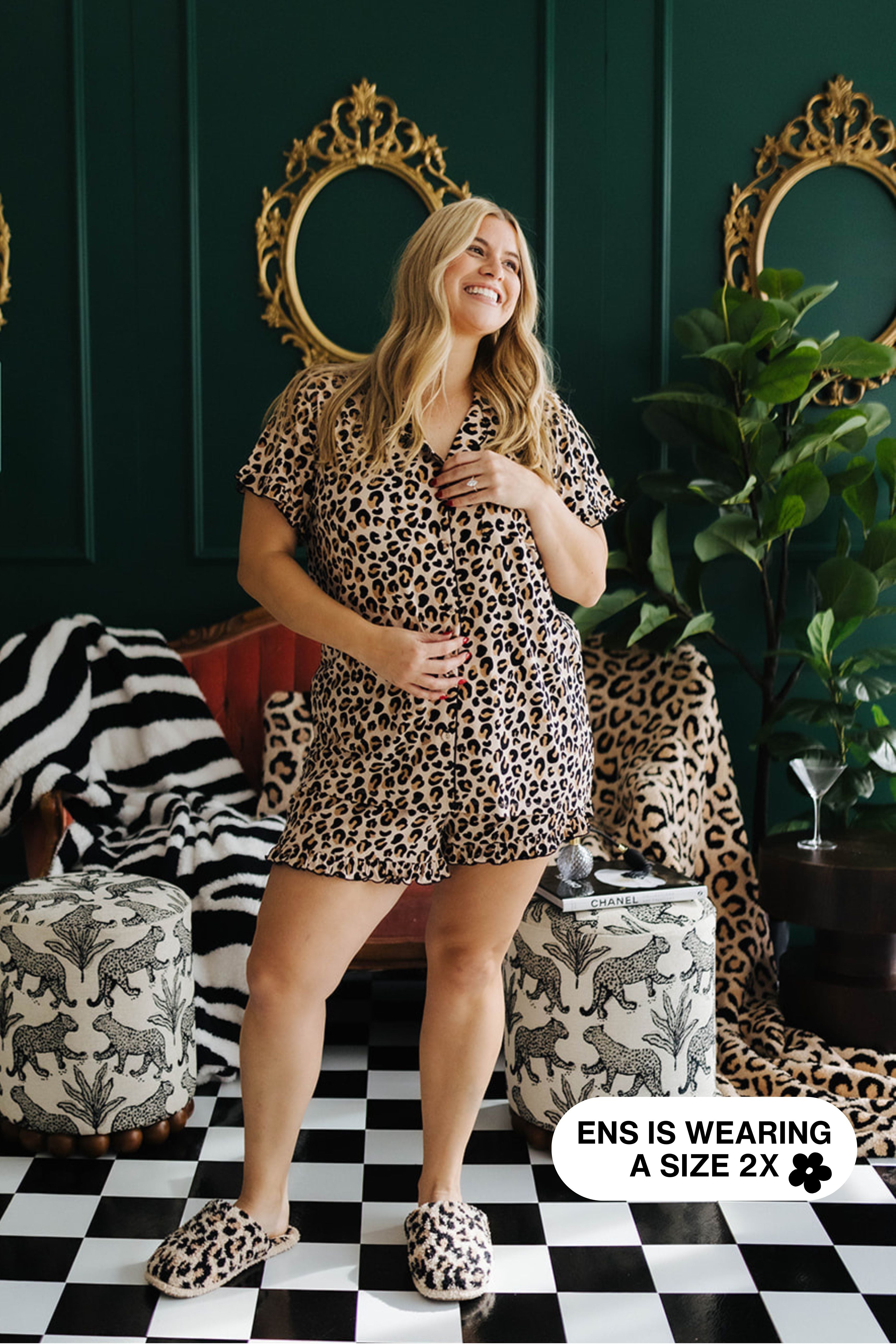 Woman wearing a leopard print outfit in a stylish room with mirrors and decor.