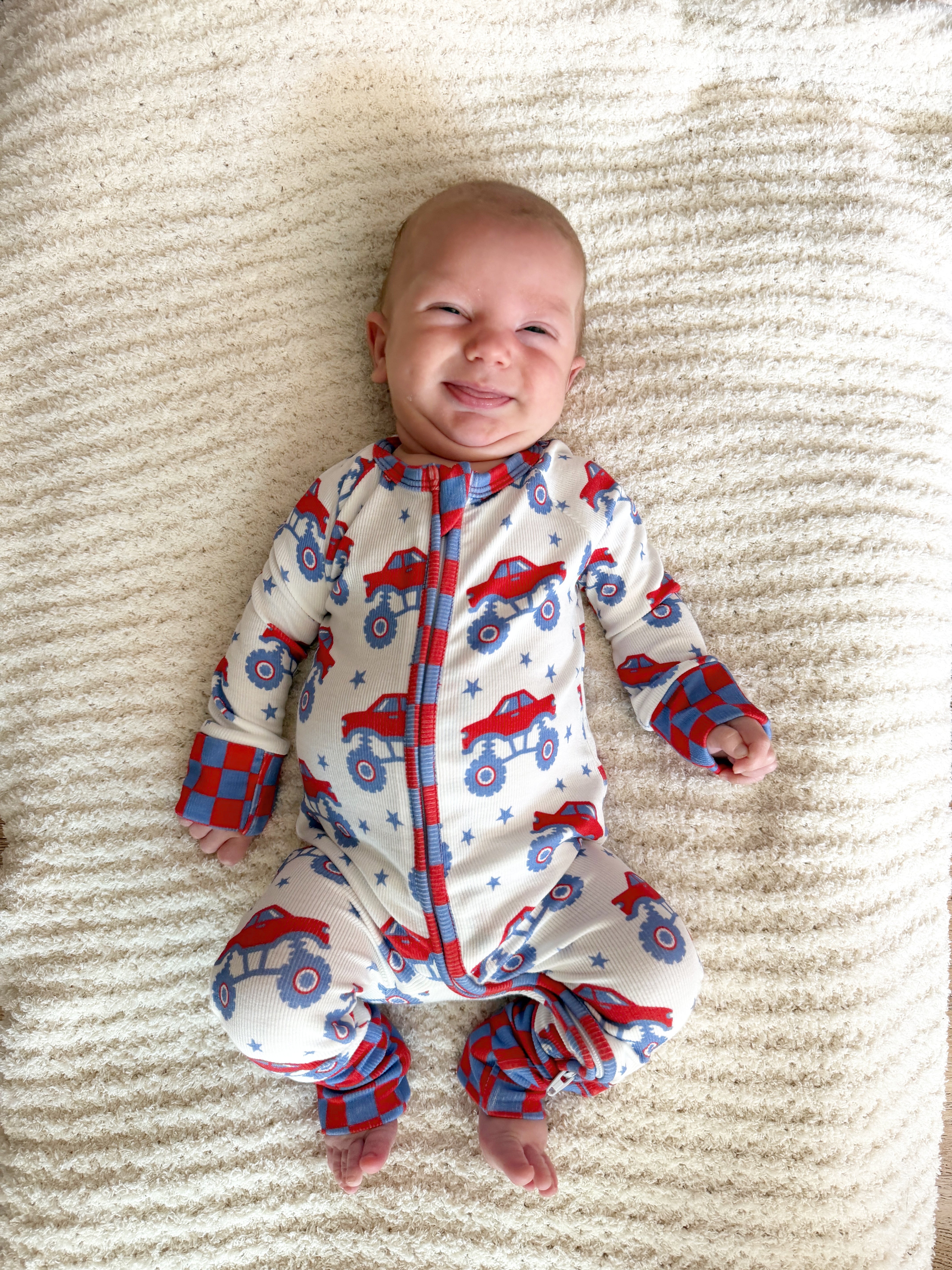 baby smiling in monster truck pjs